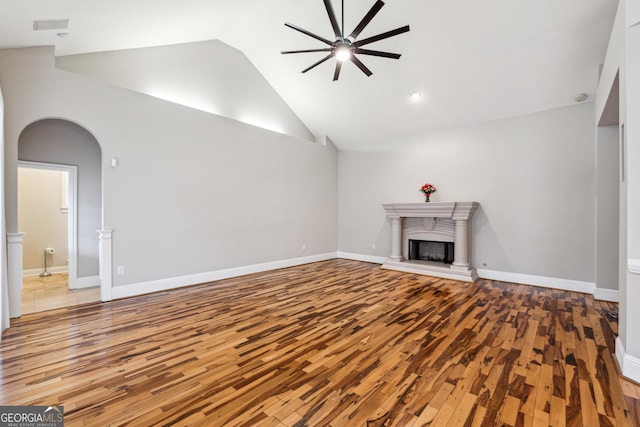 unfurnished living room with hardwood / wood-style flooring, high vaulted ceiling, and ceiling fan