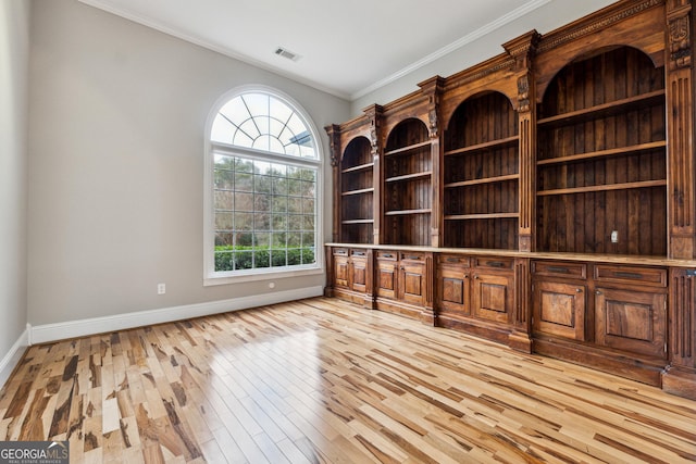 unfurnished office featuring ornamental molding and light hardwood / wood-style floors