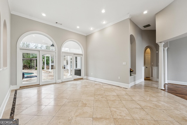 empty room featuring ornamental molding, light tile patterned floors, and ornate columns