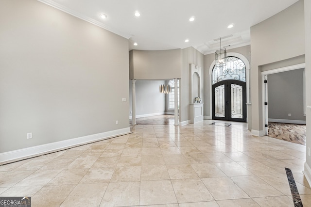 foyer entrance with crown molding, french doors, and a high ceiling