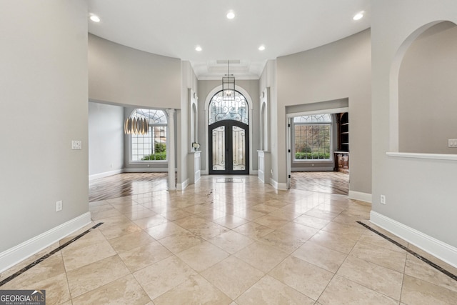 entryway featuring crown molding and french doors