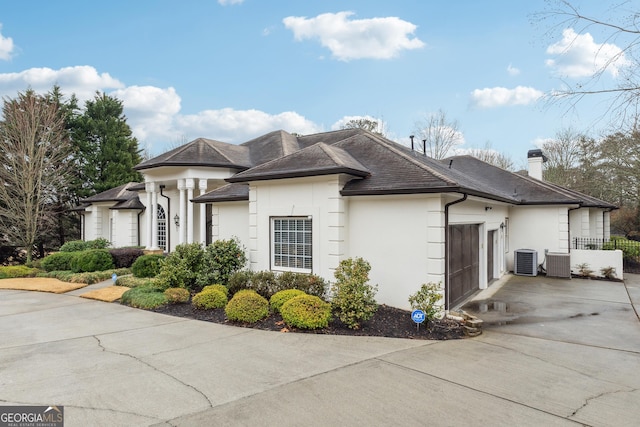 view of property exterior featuring a garage and central air condition unit