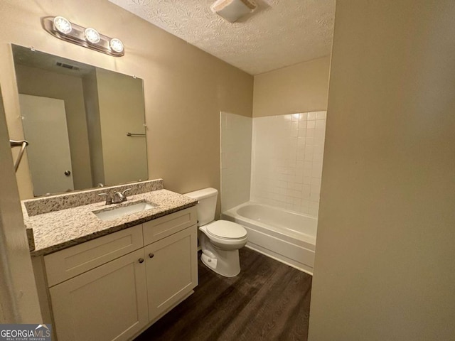 full bathroom featuring hardwood / wood-style floors, a textured ceiling, toilet, shower / tub combination, and vanity