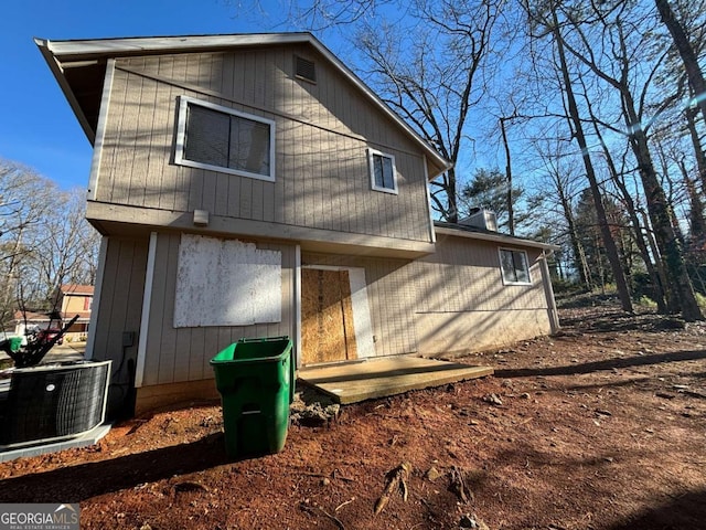 rear view of property with central air condition unit and a patio