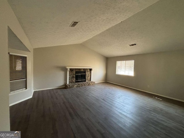 unfurnished living room featuring a fireplace, dark wood-type flooring, a textured ceiling, and vaulted ceiling