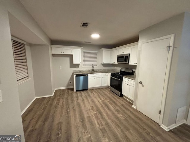 kitchen featuring sink, white cabinetry, appliances with stainless steel finishes, and dark hardwood / wood-style flooring