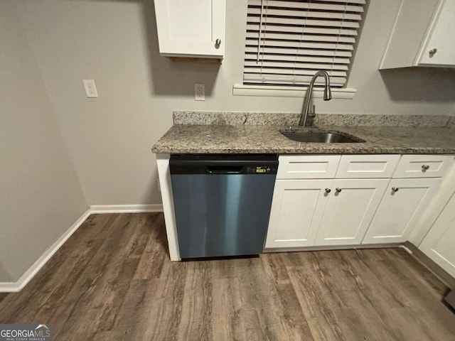 kitchen featuring dishwasher, sink, white cabinetry, dark stone counters, and dark hardwood / wood-style floors