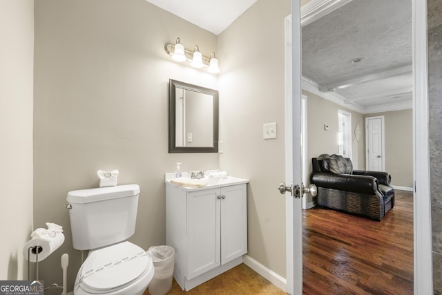 bathroom featuring vanity, toilet, ornamental molding, and wood-type flooring