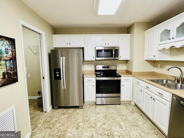 kitchen featuring sink, white cabinetry, and stainless steel appliances