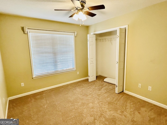 unfurnished bedroom featuring light carpet, a closet, and ceiling fan