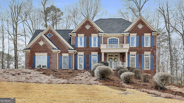 view of front of house featuring a front yard and a balcony