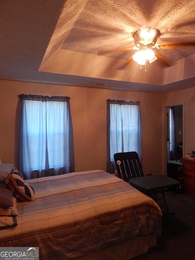 bedroom featuring ceiling fan and a tray ceiling