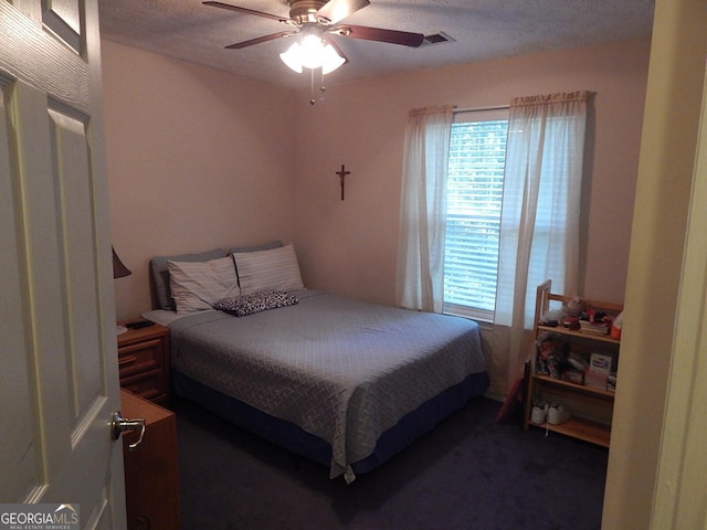 bedroom with ceiling fan and a textured ceiling