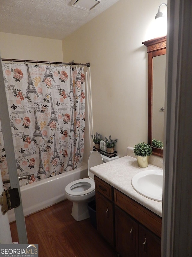 full bathroom with a textured ceiling, vanity, toilet, shower / tub combo with curtain, and hardwood / wood-style flooring