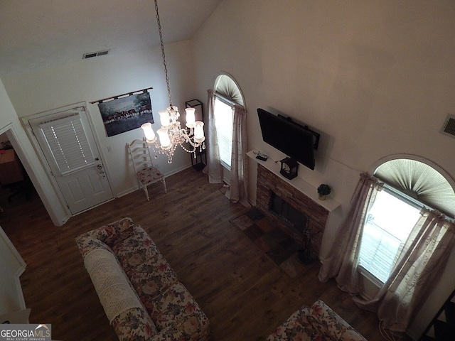 living room featuring a high ceiling, an inviting chandelier, and dark hardwood / wood-style flooring