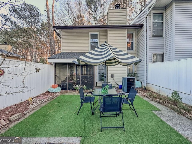 rear view of house featuring a lawn and central AC