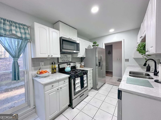 kitchen with sink, white cabinets, and appliances with stainless steel finishes