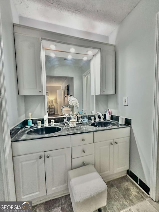 bathroom with a textured ceiling and vanity