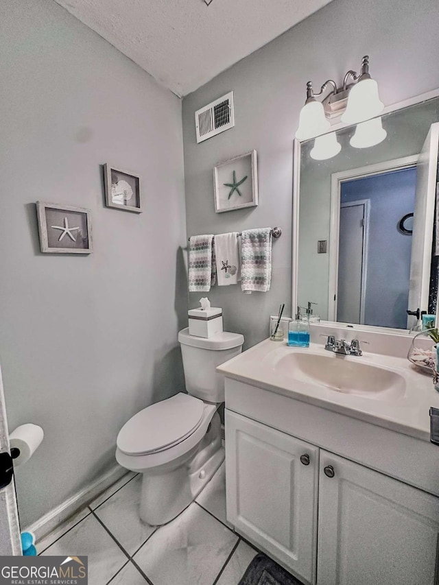 bathroom featuring a textured ceiling, tile patterned floors, vanity, and toilet