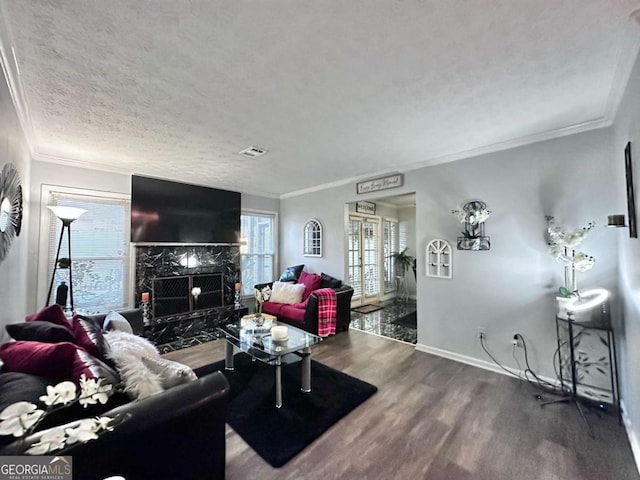 living room with a high end fireplace, ornamental molding, a textured ceiling, and wood-type flooring