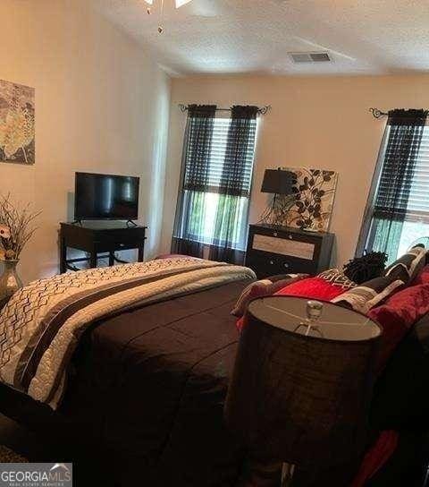 bedroom featuring multiple windows and a textured ceiling