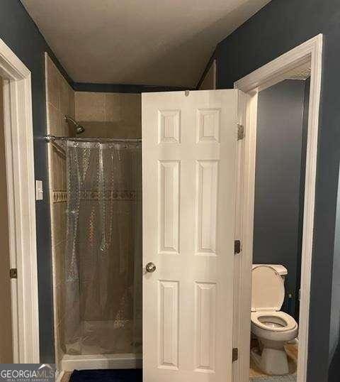 bathroom with toilet and walk in shower