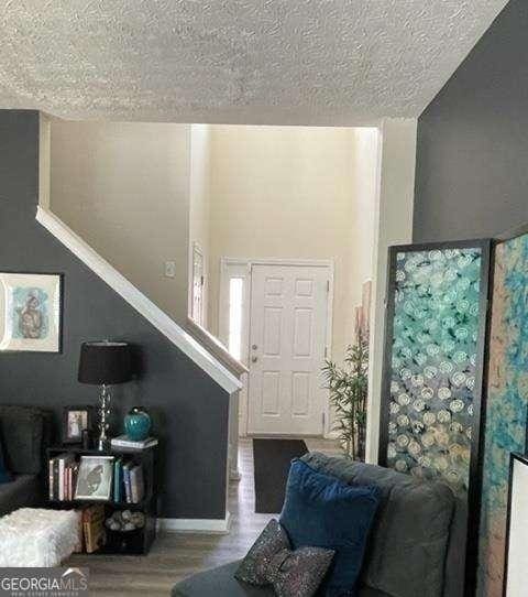 living room with a textured ceiling and wood-type flooring