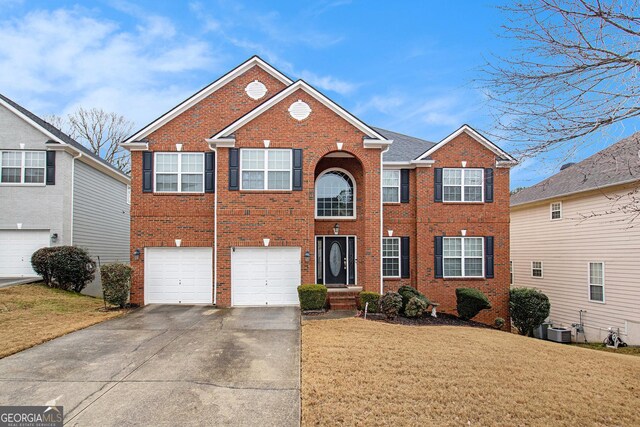 view of front of property featuring a garage, central AC unit, and a front lawn