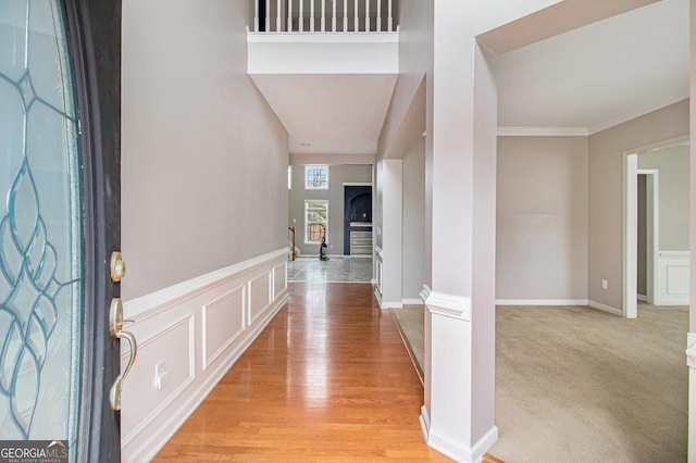 carpeted foyer with crown molding