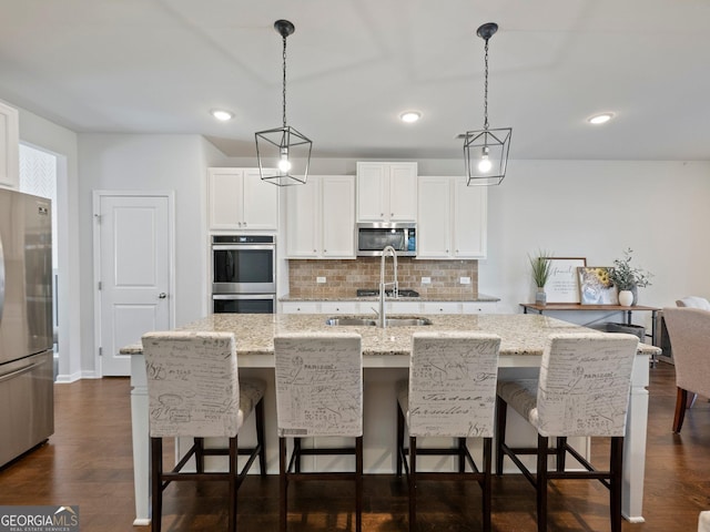 kitchen with white cabinetry, sink, a kitchen island with sink, and appliances with stainless steel finishes