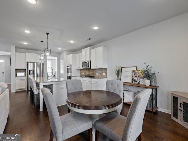 dining space with dark hardwood / wood-style flooring and sink