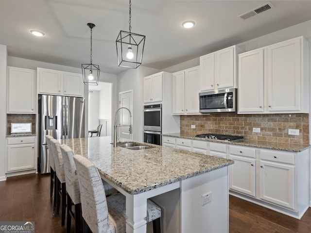 kitchen featuring sink, an island with sink, white cabinets, and appliances with stainless steel finishes