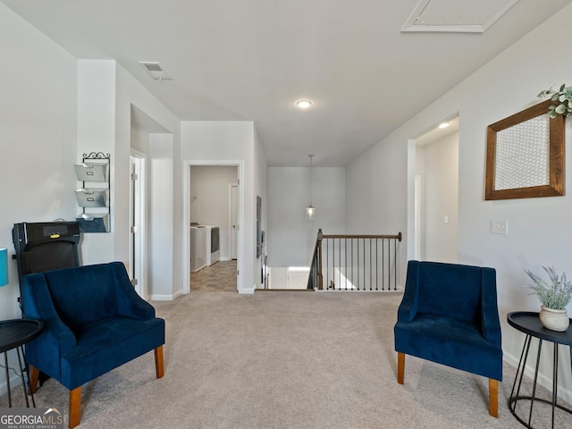 sitting room featuring carpet floors and washing machine and dryer