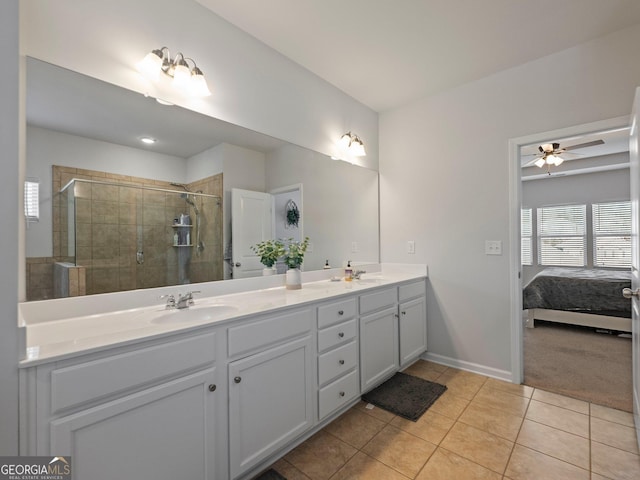 bathroom with a shower with door, vanity, tile patterned floors, and ceiling fan