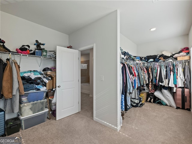 walk in closet featuring light colored carpet