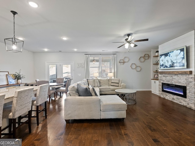 living room with ceiling fan, a fireplace, and dark hardwood / wood-style floors