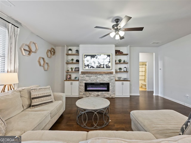 living room featuring dark hardwood / wood-style floors, a fireplace, and ceiling fan