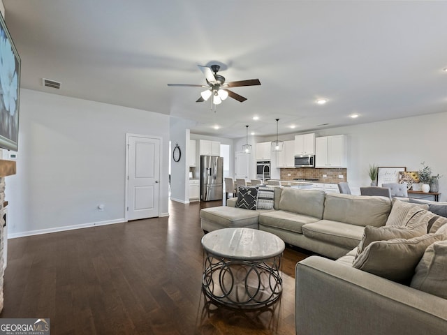 living room with ceiling fan and dark hardwood / wood-style floors