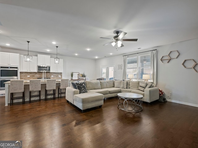 living room featuring dark wood-type flooring, sink, ceiling fan, and french doors