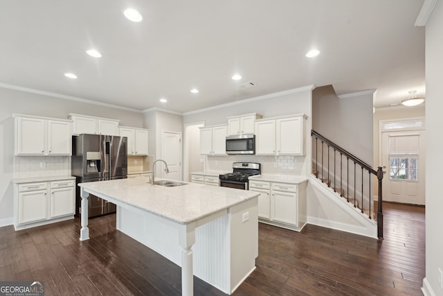 kitchen featuring sink, white cabinets, stainless steel appliances, and an island with sink