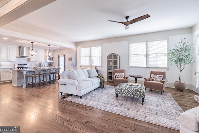 living room with dark hardwood / wood-style floors, a wealth of natural light, and ceiling fan