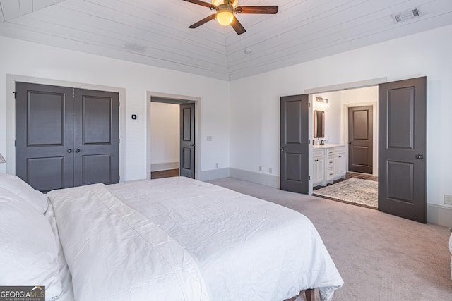 bedroom with ensuite bathroom, vaulted ceiling, ceiling fan, light carpet, and wooden ceiling