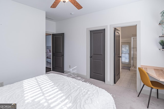 bedroom with ensuite bath, light colored carpet, and ceiling fan