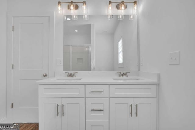 bathroom featuring vanity, an enclosed shower, and wood-type flooring