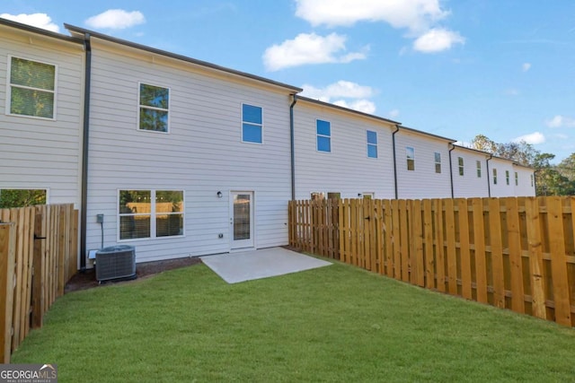 rear view of property with a patio area, central AC unit, and a lawn