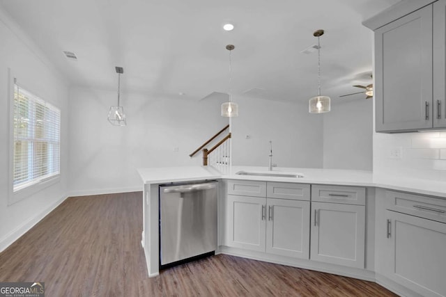 kitchen with tasteful backsplash, dishwasher, sink, decorative light fixtures, and kitchen peninsula