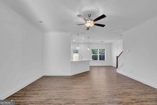 unfurnished living room featuring sink, dark hardwood / wood-style flooring, ceiling fan, and ornamental molding