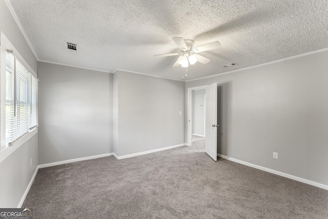 empty room with ceiling fan, crown molding, carpet floors, and a textured ceiling