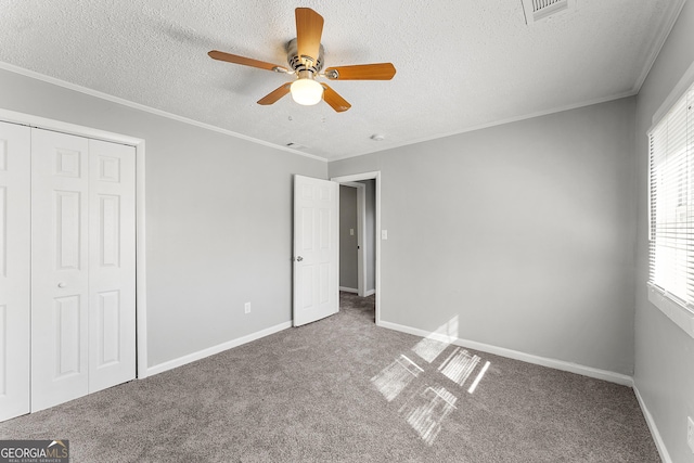 unfurnished bedroom with a closet, ceiling fan, carpet floors, and multiple windows