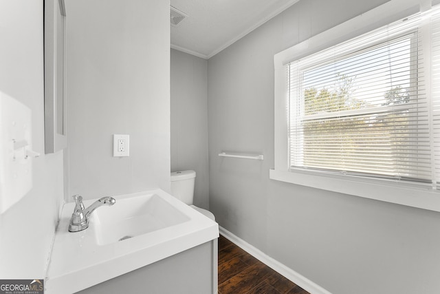 bathroom with hardwood / wood-style flooring, toilet, vanity, and ornamental molding